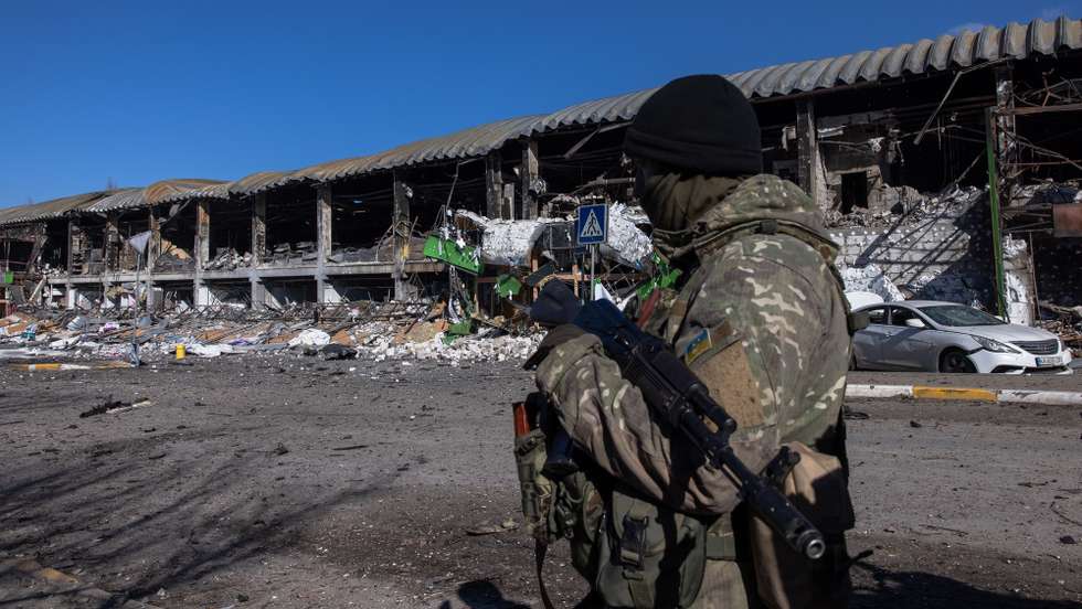 epa09815666 A Ukrainian soldier looks towards Bucha town, which is currently controlled by the Russian military, as he stands guard at the checkpoint at the frontline in Irpin town, Kyiv (Kiev) region, Ukraine, 10 March 2022. Thousands of residents are feeling Irpin and Bucha, as well as other settlements near Kyiv which were the most affected by the Russian army invasion.  EPA/ROMAN PILIPEY