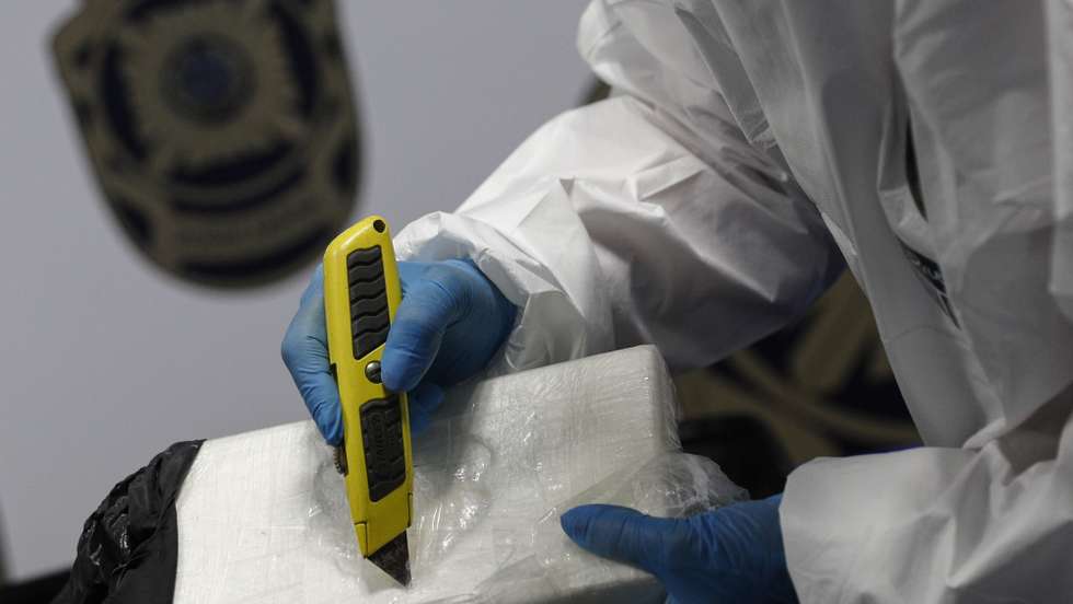Um agente da Polícia Judiciária (PJ) na apresentação da apreensão de cocaína suficiente para 1,7 milhões de doses, durante a realização da operação “White-wing”, em Lisboa, 12 de outubro de 2020. A  Polícia Judiciária deteve cinco homens por suspeitas de integrarem uma organização criminosa transnacional dedicada ao tráfico de droga que recorria a voos privados e apreendeu . Foi igualmente apreendida “uma aeronave, um jato bimotor, que foi utilizada no transporte da droga a partir da América Latina. ANTÓNIO COTRIM/LUSA