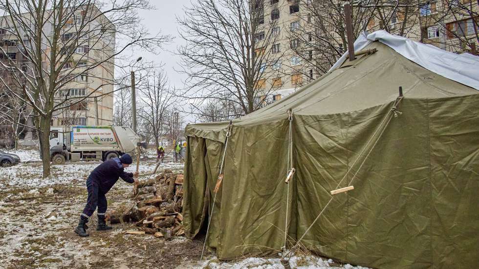 epa10325909 A municipal worker prepares fire-wood for the 'Invincibility' point in the North Saltivka district in Kharkiv, Ukraine, 24 November 2022, amid Russia's military invasion. Kharkiv and surrounding areas have been the target of heavy shelling since February 2022, when Russian troops entered Ukraine starting a conflict that has provoked destruction and a humanitarian crisis. At the beginning of September, the Ukrainian army pushed Russian forces from occupied territory northeast of the country in counterattacks.  EPA/SERGIY KOZLOV