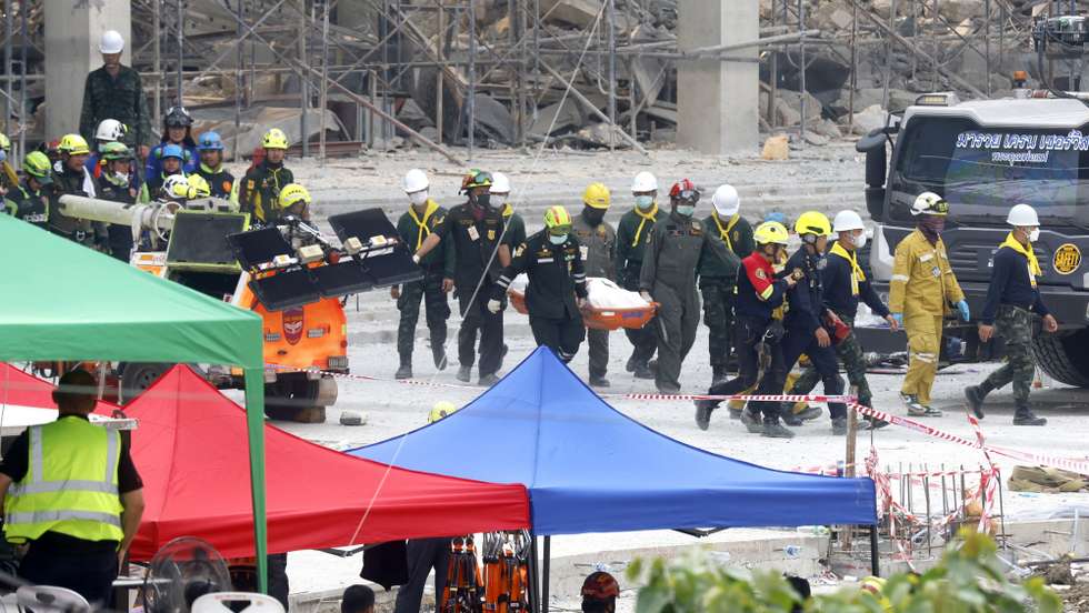 epa12002715 Rescue workers carry a victim's body retrieved from the site of a building that collapsed following an earthquake in Bangkok, Thailand, 01 April 2025. At least 20 people were confirmed dead, 34 injured, and 78 remained missing in Bangkok, including at least 13 people who were killed after a 30-floor building collapsed due to tremors from the 7.7-magnitude earthquake that struck Myanmar, according to the Erawan Medical Emergency Center.  EPA/NARONG SANGNAK