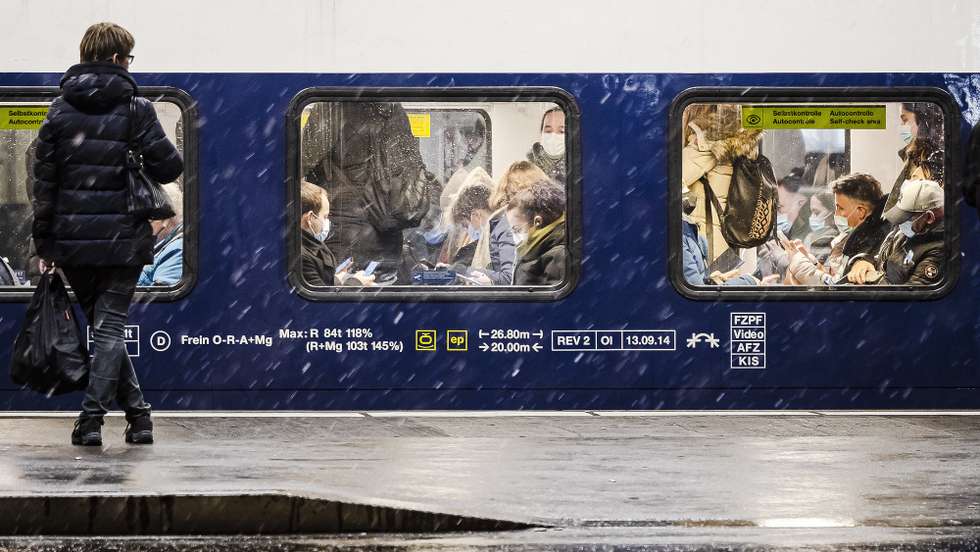 epa09613160 Commuters wear face masks to curb the spread of COVID-19 as they get on a public train in Zurich, Switzerland, on 30 November 2021.  EPA/MICHAEL BUHOLZER