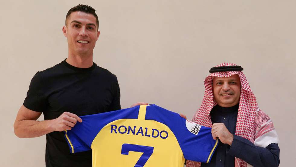 epa10383112 A handout photo made available by the Saudi Al-Nassr Club on 30 December shows Portuguese soccer player Cristiano Ronaldo posing for a photograph with the club's jersey after signing with Al-Nassr, in Riyadh, Saudi Arabia. Al-Nassr Club announced on 30 December that Ronaldo signed a contract that runs untill 2025.  EPA/AL-NASSR CLUB HANDOUT  HANDOUT EDITORIAL USE ONLY/NO SALES