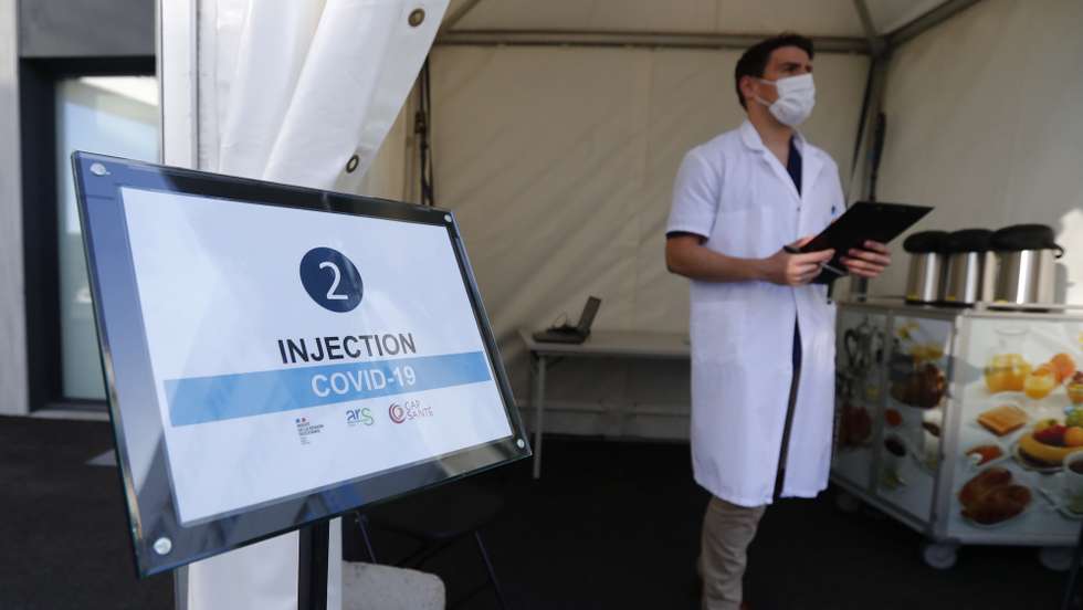 epa09132194 Medical personnel await the arrival of cars in the first drive-thru Covid-19 vaccination center in France, dubbed a 'Vaccidrive', where medical staff administer vaccine injections against Covid-19 coronavirus to patients inside their vehicle, outside the clinic of Saint-Jean-de-Vedas near Montpellier, in southern France, 13 April 2021.  EPA/GUILLAUME HORCAJUELO