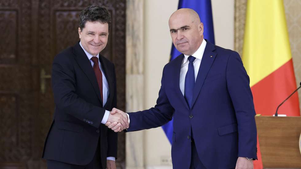 epa12187337 Romania's President Nicusor Dan (L) and designated Prime Minister Ilie Bolojan (R) shake hands at the end of a joint media statement at Cotroceni Presidential Palace in Bucharest, Romania, 20 June 2025. President Dan appointed Ilie Bolojan as prime minister-designate to form a government team and to appear before the Romanian Parliament for the vote of confidence.  EPA/ROBERT GHEMENT