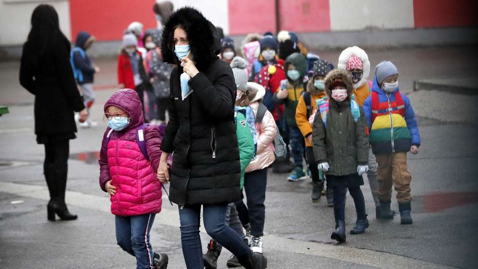 epa08995781 A school teacher guides the children towards the school entrance, from the school yard, during the first day of school at &#039;Cezar Bolliac Secondary School&#039;  in Bucharest, Romania, 08 February 2021. Primary schools have reopened in Romania starting 08 February 2021, depending on the incidence rate of coronavirus infections per thousand inhabitants, in accordance with the yellow scenario. The incidence rate of COVID-19 infections per thousand inhabitants in Bucharest is at 1.12 .  EPA/ROBERT GHEMENT