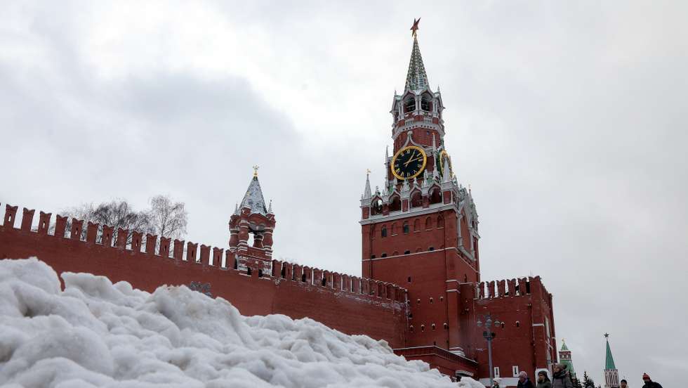 epa12613064 People walk past heaps of snow outside the Kremlin during snowfall in Moscow, Russia, 26 December 2025.  EPA/MAXIM SHIPENKOV