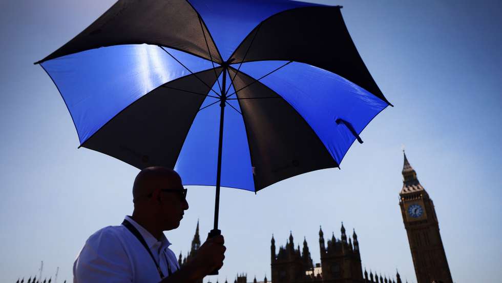 epaselect epa12992997 A pedestrian shelters from the sun on Westminster Bridge in London, Britain, 25 May 2026. The UK has recored it’s hottest May day on record expected to reach temperatures of 35 Celcius as a heat wave continues.  EPA/ANDY RAIN