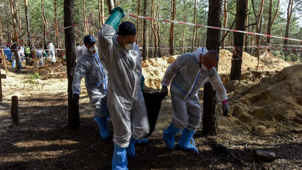 epa10199573 Workers move an exhumed body on the cemetery in Izyum, Kharkiv region, Ukraine, 22 September 2022. The Ukrainian army pushed Russian troops from occupied territory in the northeast of the country in a counterattack. Kharkiv and surrounding areas have been the target of heavy shelling since February 2022, when Russian troops entered Ukraine starting a conflict that has provoked destruction and a humanitarian crisis.  EPA/OLEG PETRASYUK
