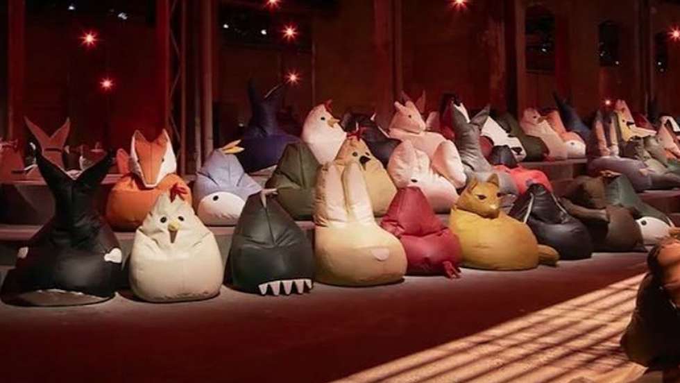 Uma imagem dos pufes organizados na sala de desfile antes de receber os convidados e começar