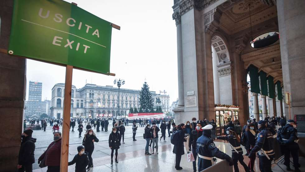 epa08892304 Barriers and officers of the Local Police regulate the influx of visitors to avoid crowds at the entrance to Piazza Duomo of the Vittorio Emanuele Gallery, in Milan, Italy, 18 December 2020. Italian Premier Giuseppe Conte's government looks set to approve restrictions that will put Italy into some form of a lockdown over the Christmas holidays to stop social contact during the festive season feeding a third wave of COVID-19 contagion in the country.  EPA/MATTEO CORNER