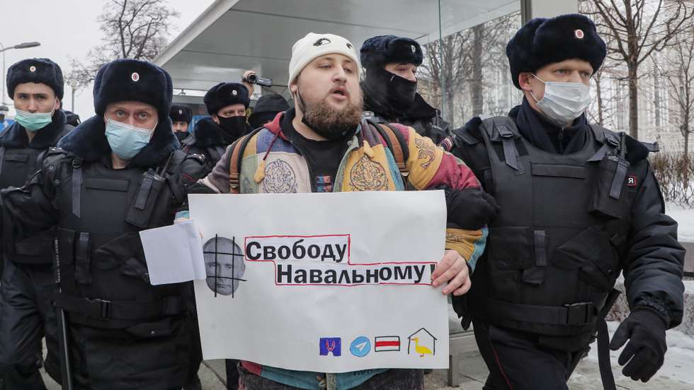 epa08959290 Police officers remove a protester holding a poster showing Russian President Vladimir Putin and reading 'Freedom for Navalny' during an unauthorized protest in support of Russian opposition leader and blogger Alexei Navalny, in Moscow, Russia, 23 January 2021. Navalny was detained after his arrival to Moscow from Germany on 17 January 2021. A Moscow judge on 18 January ruled that he will remain in custody for 30 days following his airport arrest. Navalny urged Russians to take to the streets to protest. In many Russian cities mass events are prohibited due to an increasing number of cases of the COVID-19 pandemic caused by the SARS CoV-2 coronavirus.  EPA/MAXIM SHIPENKOV