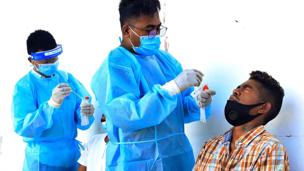 epa09407850 A health worker collects a specimen sample from a man during a COVID-19 swab test in Dili, East Timor, known also as Timor Leste, 10 August 2021. East Timor has officially recorded more than 10,000 coronavirus disease (COVID-19) cases since the beginning of the pandemic.  EPA/ANTONIO DASIPARU