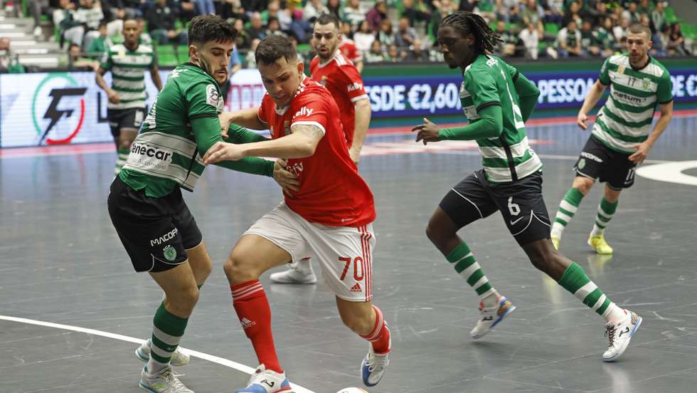 O jogador do Sporting, Tomás (E), disputa a bola com o jogador do Benfica, Rocha (C), durante a 13.ª jornada da fase regular da Liga de futsal, no Pavilhão João Rocha, em Lisboa, 13 de janeiro de 2023. ANTÓNIO PEDRO SANTOS/LUSA