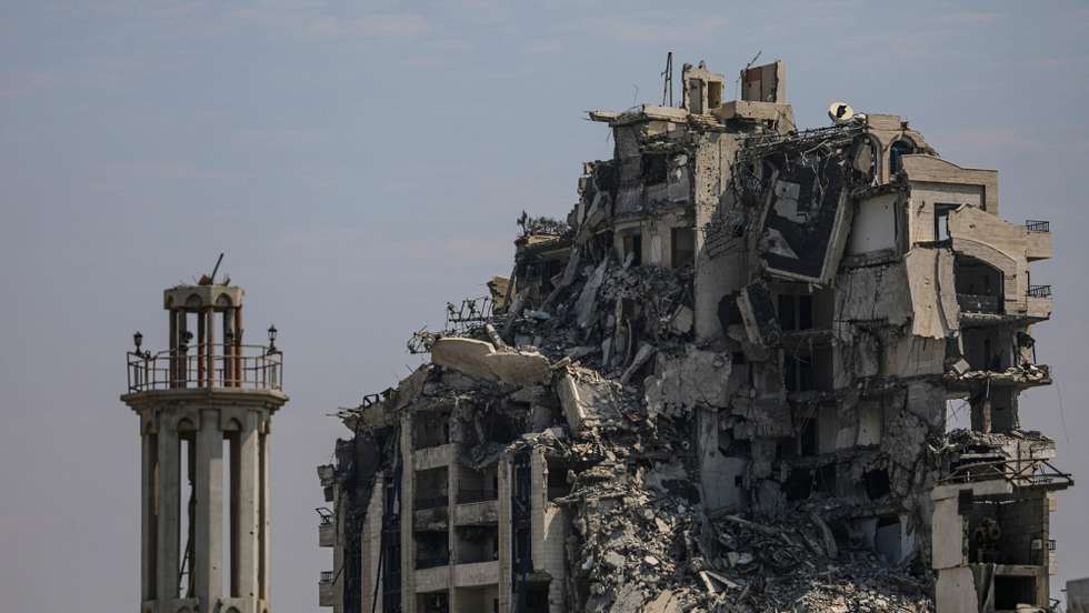 epa12268884 The minaret of a destroyed mosque stands near a damaged building in Gaza City, 28 July 2025.  EPA/MOHAMMED SABER