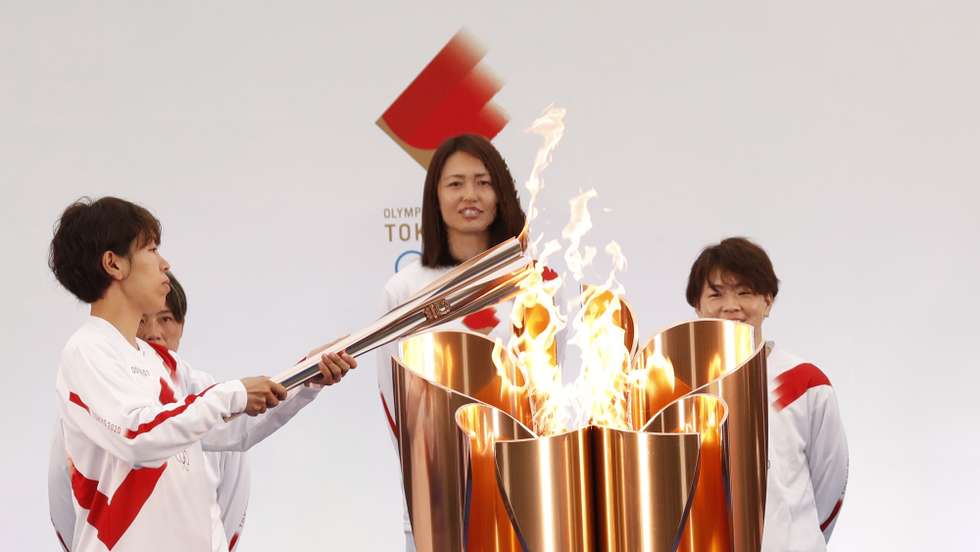 epa09095217 The Olympic torch is lit by a member of Japan's women's national soccer team Nadeshiko Japan during the Tokyo 2020 Olympic Torch Relay Grand Start in Naraha, Fukushima prefecture, Japan, 25 March 2021. The postponed Tokyo 2020 Olympic Games are scheduled to start on 23 July 2021 and some 10,000 torchbearers will run across the country along a 121-day journey.  EPA/KIM KYUNG-HOON / POOL