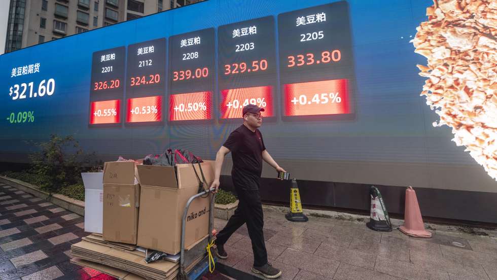 epa09510807 A man walks in front of the screen showing newest stock exchange and economic data in Shanghai, China, 07 October 2021. A debt crisis and rising bond yields of China Evergrande Group made a whirlwind for other Chinese real estate developers who suspended their stock trading this week in the Hong Kong market. There are concerns and speculations in the Hong Kong stock market over the uncertainty and market value.  EPA/ALEX PLAVEVSKI