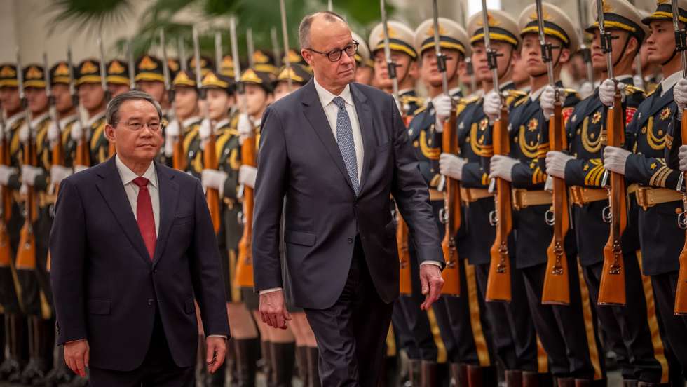 epa12775435 Chancellor of Germany Friedrich Merz (C) is welcomed with military honors at the Great Hall of the People by Li Qiang (L), Premier of China, in Beijing, China, 25 February 2026. Merz is visiting China for the first time as Chancellor.  EPA/Michael Kappeler / POOL