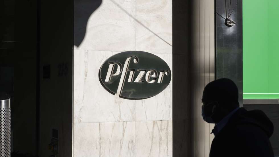 epa08810220 A person walks past the headquarters of the pharmaceutical company Pfizer in New York, New York, USA, 09 November 2020. Pfizer announced earlier on the same day that a coronavirus vaccine it was developing with the German drugmaker BioNTech was showing a 90 percent effectiveness in preventing COVID-19 earlier trials.  EPA/JUSTIN LANE