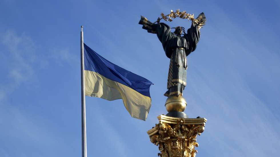 epaselect epa09786831 A national flag waves in front of the Independence Monument on the central Indepencence Square of Kiev, Ukraine, 26 February 2022. Russian troops entered Ukraine on 24 February prompting the country's president to declare martial law and triggering a series of announcements by Western countries to impose severe economic sanctions on Russia.  EPA/ZURAB KURTSIKIDZE
