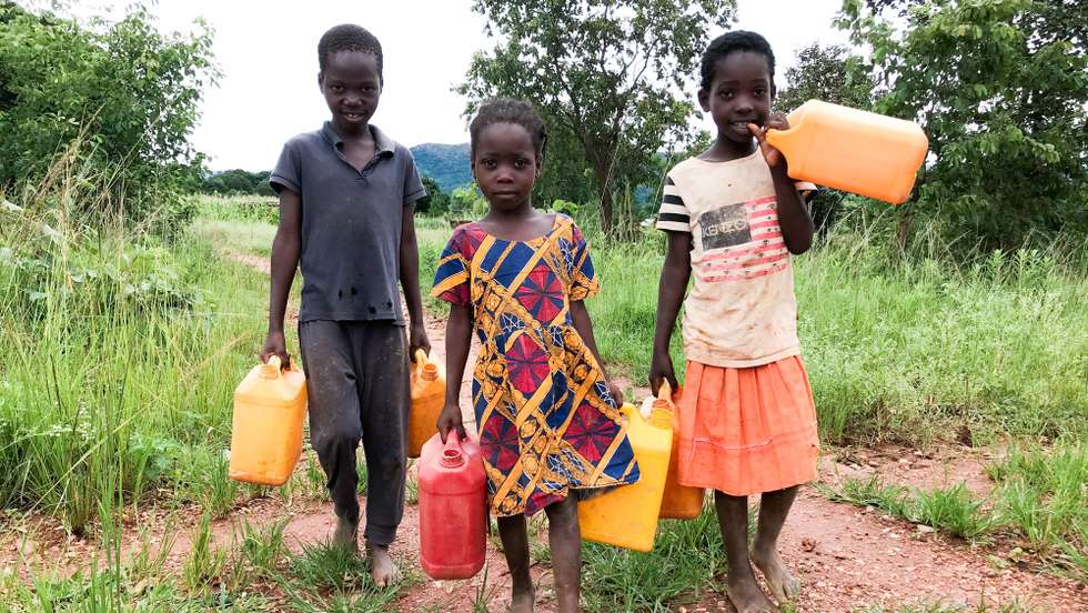Ciranças caminham para ir buscar água no dstrito de Manica, Moçambique, 26 de fevereiro de 2021. Um total de 92 crianças foram identificadas pelos 114 Comités Comunitários de Proteção a Criança, criados pela Save The Children, como estando em situação de risco de uniões prematuras em 2020 nos distritos de Manica, Machaze, Macossa e Tambara, tendo 47 sido resgatadas. (ACOMPANHA TEXTO DA LUSA DO DIA 01 DE MARÇO DE 2021). ANDRÉ CATUEIRA/LUSA