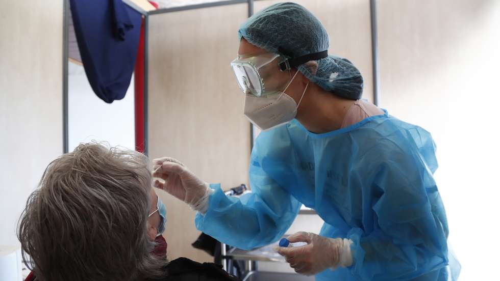 epa08998578 A medical worker takes nasal swab samples at a test station for Covid-19 coronavirus in Montpellier, France, 09 February 2021. The top French medical authority (Haute autorite de Sante) has approved the vaccine AstraZeneca-Oxford for use in France, but only for people under 65, echoing decisions made in Sweden, Germany, Belgium and Switzerland over concerns about a lack of data on the effectiveness of the vaccine for over 65s.  EPA/GUILLAUME HORCAJUELO