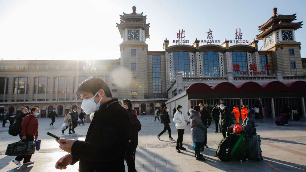 epaselect epa10397602 Passengers wearing face masks walk with their luggage in front of the Beijing Railway Station in Beijing, China, 10 January 2023. Chinese passengers are travelling domestically as the nation's most important holiday season kicked off, after the end of China's zero-COVID policy that was in place for three years. Some 34 million trips across the country were made by road, railway, water or air on 07 January on the first day of the Lunar New Year travel rush, according to the data released by the Ministry of Transport.  EPA/WU HAO