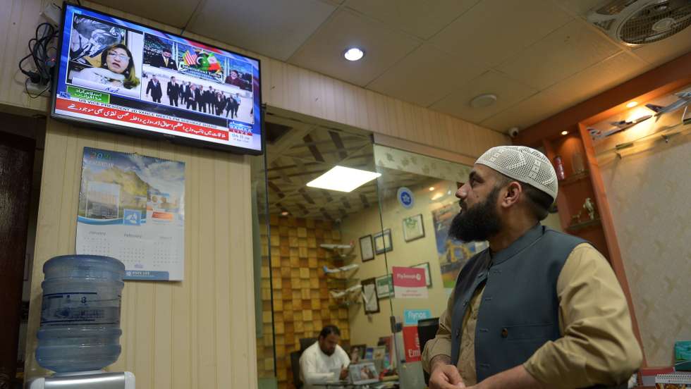 epa12882358 People watch the arrival of US Vice President JD Vance along with other delegates in Islamabad for peace talks between the US and Iran on a television in an office in Peshawar, Pakistan, 11 April 2026. An Iranian and US delegation arrived in Islamabad for planned peace talks amid a fragile two-week ceasefire following the conflict that began on 28 February 2026.  EPA/BILAWAL ARBAB