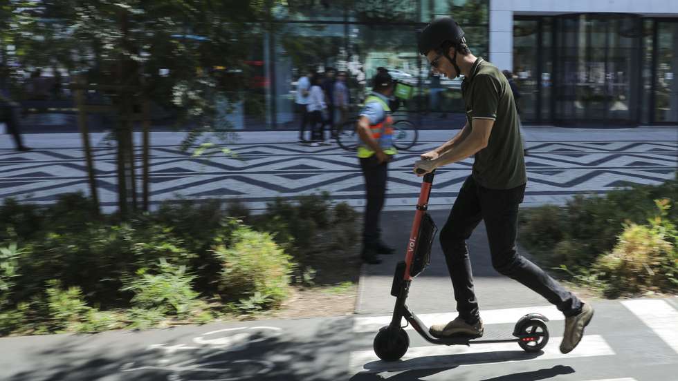 Um popular passa de trotinete a usar o capacete no dia do lançamento da campanha nacional “Não sejas Alberto, usa capacete!”, uma ação de sensibilização onde são demonstrados os efeitos de não usar capacete na condução de bicicletas e trotinetes na via pública. Lisboa, 28 de agosto de 2019. MIGUEL A. LOPES/LUSA