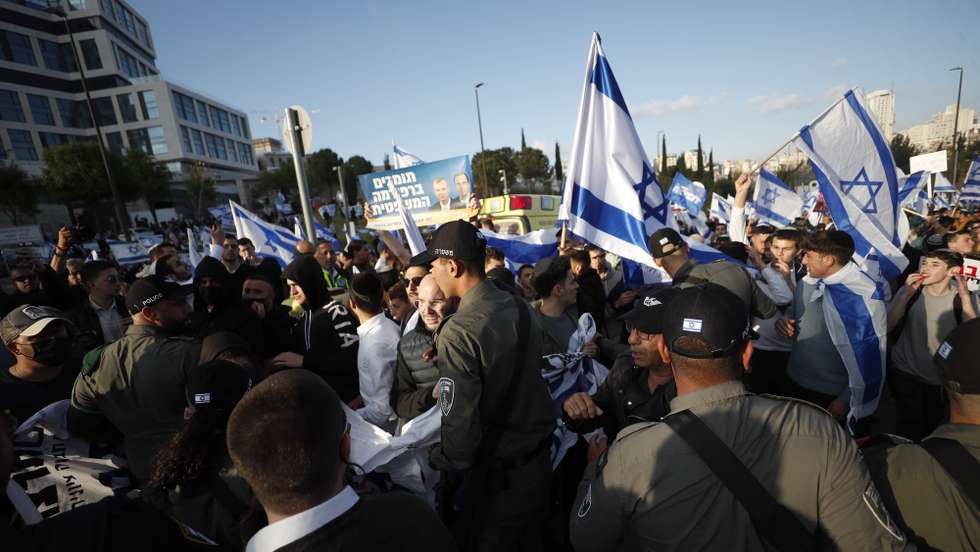 epa10545782 Israeli police try to separate Israeli Right-wing government supporters and anti-government protesters, as they gather outside the Knesset (the Parliament), ahead of mass protests in Jerusalem, Israel, 27 March 2023. Mass protests have been held in Israel for 12 weeks against the government's plans to reform the justice system and limit the power of the Israeli Supreme Court.  EPA/ATEF SAFADI