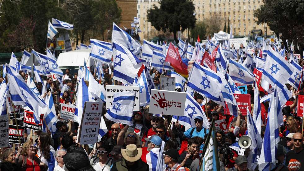 epa10545111 Protesters gather outside the Knesset ahead of mass protests in Jerusalem, Israel, 27 March 2023. Mass protests have been held in Israel for 12 weeks against the government's plans to reform the justice system and limit the power of the Israeli Supreme Court.  EPA/ATEF SAFADI
