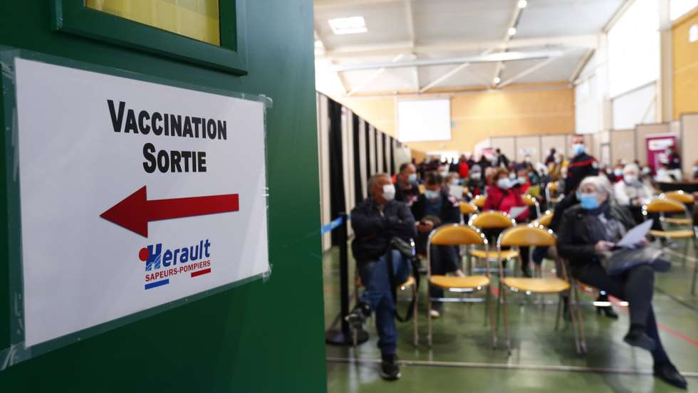 epa09121887 People waiting after receiving a dose of the Pfizer-BioNTech COVID-19 vaccine by a firefighter at a vaccination centre set up at the fire station of Vailhauques, France, 08 April 2021. New restrictions have been implemented in France, including a brief closure of schools, to keep Covid-19 cases down before the effects of the vaccine drive kick in.The banner reads 'Vaccination exit'. EPA/GUILLAUME HORCAJUELO