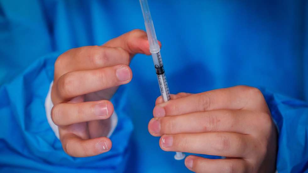 epa09614277 A health worker prepares a dose of COVID-19 vaccine during a vaccination drive at Lotto Park Stadium in Brussels, Belgium, 01 December 2021. Since 29 November 2021, a third dose of COVID-19 vaccine, also called 'booster dose', is available (via appointment) for all residents of the Brussels-Capital Region from 18-year-old who wish to receive it.  EPA/STEPHANIE LECOCQ