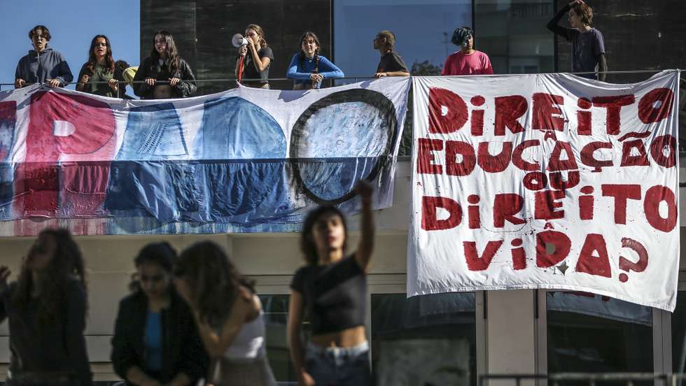 Um grupo de alunos da escola secundária Antonio Arroio colou-se às portas da escola, bloqueando a entrada, em protesto pelo fim dos combustíveis fósseis, e houve estudantes em protesto no telhado, em Lisboa, 10 de novembro de 2022. Os alunos estão desde segunda-feira a ocupar a escola, num protesto que se repete em outras cinco escolas e faculdades da capital com uma reivindicação comum: o fim dos combustíveis fósseis. RODRIGO ANTUNES/LUSA