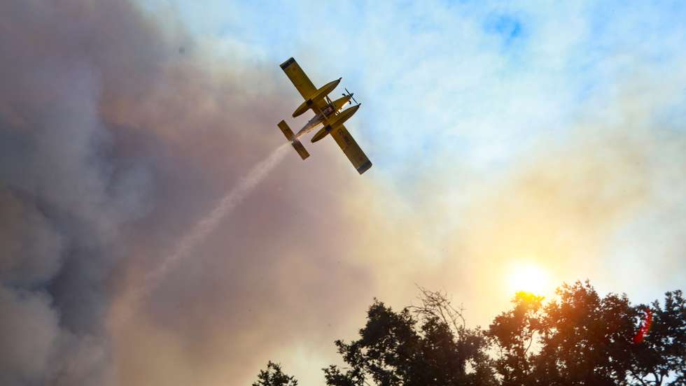 Um avião combate um incêndio que lavra numa zona de mato na freguesia de Benespera, no concelho da Guarda, 07 de julho de 2022. De acordo com a página da Autoridade Nacional de Emergência e Proteção Civil, o incêndio está a ser combatibo por mais de 325 operacionais, apoiados por 96 viaturas e 04 meios aéreos. MIGUEL PEREIRA DA SILVA/LUSA