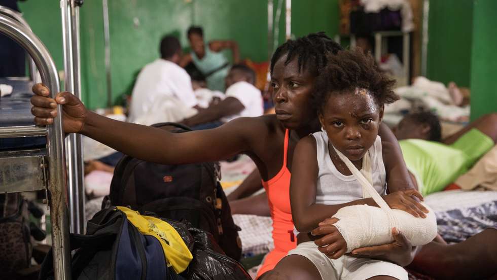 epa09419440 Daline Noel carries her daughter Bernard Lenise, who remains confined at the Immaculee Conception General Hospital, after the earthquake of August 14, in Les Cayes, Haiti, 18 August 2021. The 7.2 magnitude earthquake registered last 14 August in Haiti and which mainly hit the South department, whose capital is Les Cayes, caused serious material damage, at least 1,941 dead and 9,900 injured.  EPA/Orlando BarrÃ­a