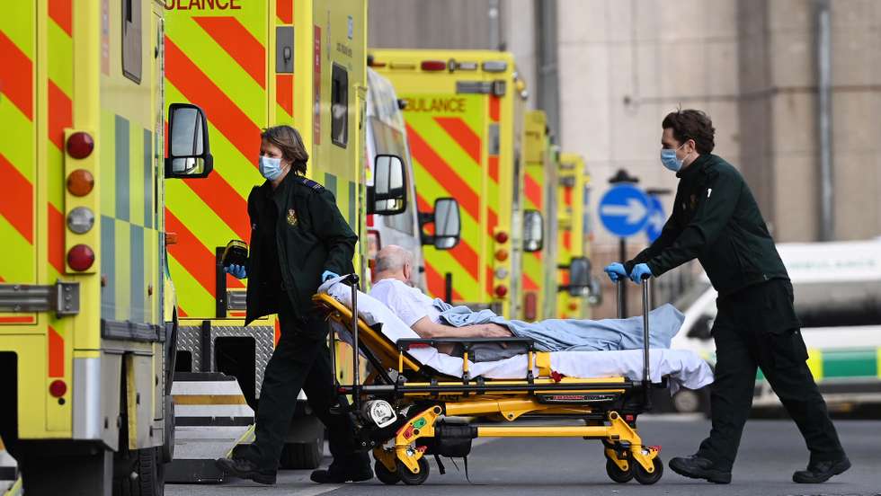 epa09009140 Ambulance staff push a bed with an patient outside the Royal London hospital in London, Britain, 13 February 2021. Britain's National health service (NHS) has been under sever pressure even as Covid-19 hospital admissions continue to fall across the UK.  EPA/ANDY RAIN