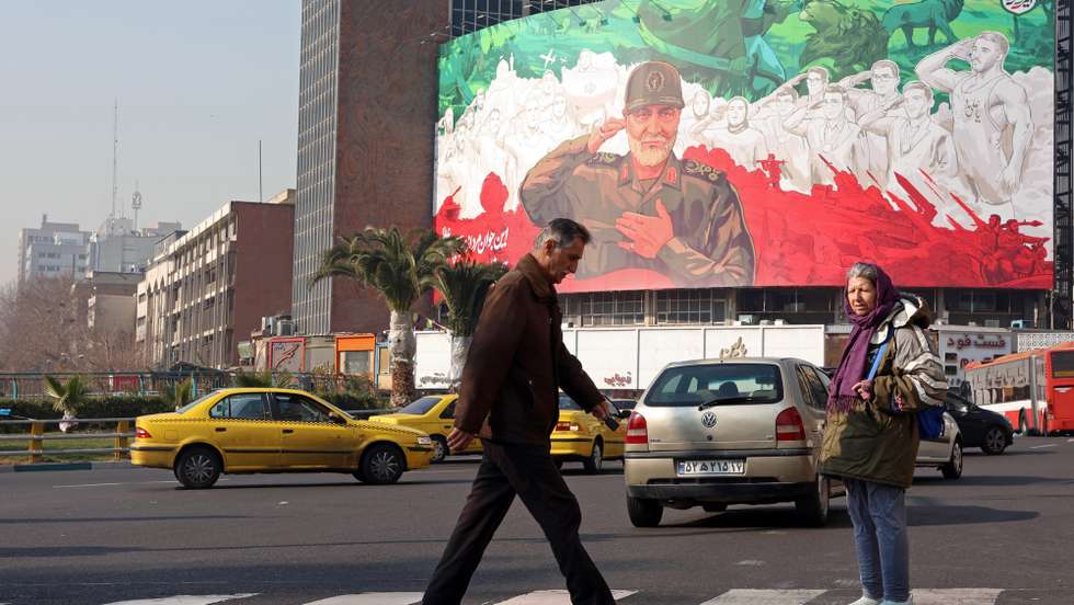 epa12630229 People walk past a billboard depicting former Iran Islamic Revolutionary Guard Corps (IRGC) Quds Force commander Qasem Soleimani in downtown Tehran, Iran, 06 January 2026. The country is facing a wave of anti-government protests amid a deepening economic crisis, fueled by rising prices of basic goods and a sharp decline in the national currency, driven by regional tensions with Israel and the US, as well as longstanding US and EU sanctions.  EPA/ABEDIN TAHERKENAREH