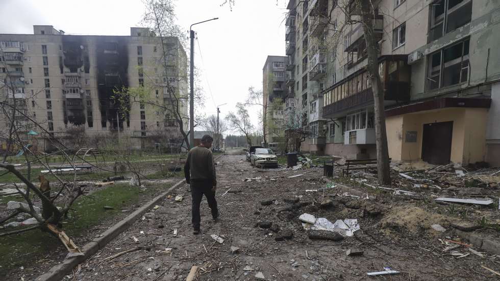 epa09893603 A man walks past a residential building damaged during a shelling in Severodonetsk, North-West of Luhansk, Ukraine, 16 April 2022. Russian troops entered Ukraine on 24 February resulting in fighting and destruction in the country and triggering a series of severe international economic sanctions on Russia.  EPA/STR