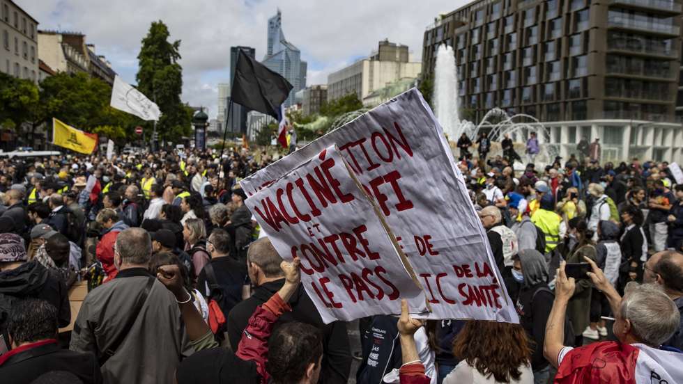 epa09404306 Protesters surrounded by anti-riot forces march during a demonstration against the COVID-19 health pass which grants vaccinated individuals greater ease of access to venues in France, in Paris, France, 07 August 2021. The national enforcement of the 'Health Pass' is expected to take effect on 09 August, after the French Constitutional Council has confirmed the government's law which extend the use of its Vaccinal Passeport (a QR code which proves the bearer has received full vaccination, or been tested negative for Covid in the last 72 hours) to cultural place, transport, and restaurants among other places.  EPA/IAN LANGSDON