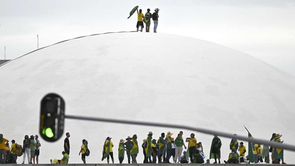 epa10997277 Supporters of Brazil's former president Jair Bolsonaro walk on the dome of the National Congress during a protest in Brasilia, Brazil, 08 January 2023. Hundreds of Bolsonaro supporters stormed the headquarters of the National Congress, the Supreme Court, and the Planalto Palace, the seat of the Presidency of the Republic, in a demonstration calling for a military intervention to overthrow President Luiz Inacio Lula da Silva.  EPA/ANDRE BORGES