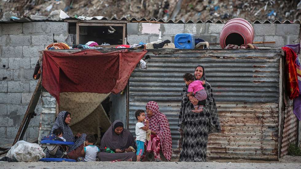 epa08507041 Palestinian refugees mothers sit outside their families houses with their babies in Khan Younis refugee camp in the southern Gaza Strip, 24 June 2020.  EPA/MOHAMMED SABER