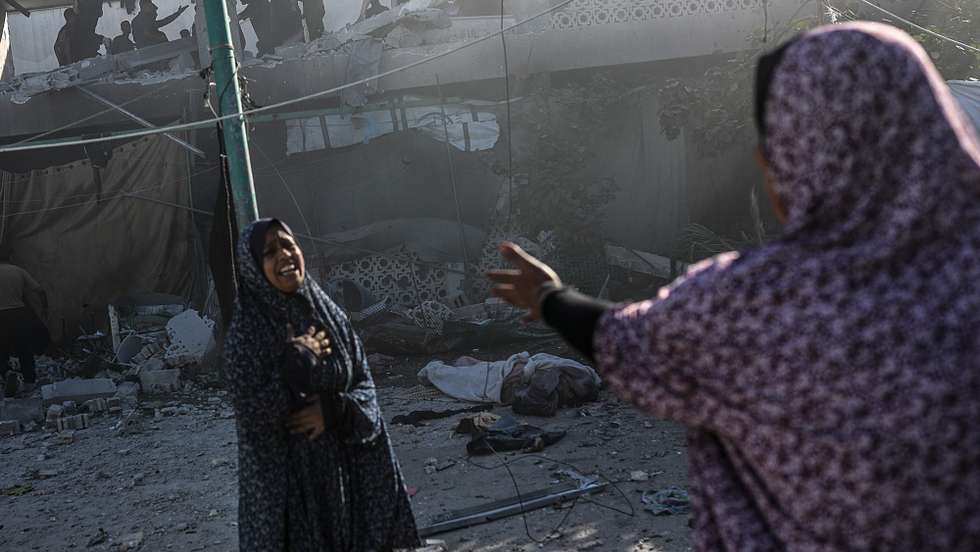 epa12054610 Two Palestinian women react near a body (R, rear) following an Israeli airstrike, at Al Farabi school in Gaza City, northern Gaza Strip, 25 April 2025. According to the Palestinian Ministry of Health in Gaza, at least three Palestinians were killed and 10 others wounded in Israeli airstrikes.  EPA/MOHAMMED SABER