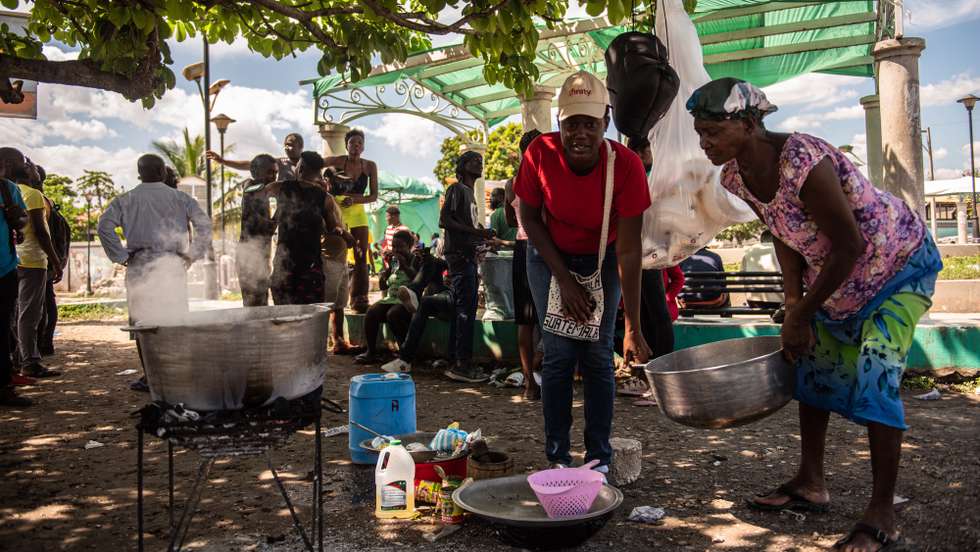 epa09911105 Women prepare to cook after leaving the Croix-des-Bouquets area to avoid clashes between armed gangs in Port-au-Prince, Haiti, 26 April 2022.  EPA/Sabin Johnson