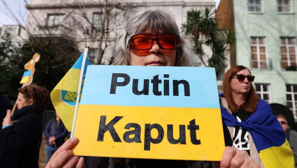 epa11915788 A protestor holds a placard during a march to the Russian embassy during a rally for Ukraine in London, Britain, 22 February 2025. People gather to mark the three-year anniversary of the Russian invasion of Ukraine on 24 February 2022.  EPA/ANDY RAIN