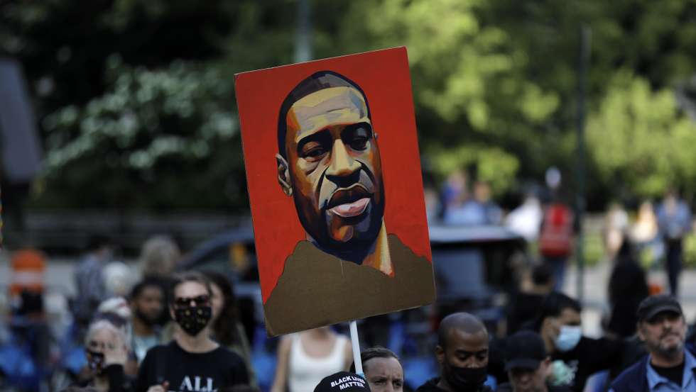epa09227919 A demonstrator carries a drawing of George Floyd at the one year anniversary protest of George Floyd's death in lower Manhattan in New York, New York, USA, 25 May 2021. Exactly one year has passed since George Floyd was killed in Minneapolis, Minnesota, after now-convicted former police officer Derek Chauvin kneeled on Floyd's neck for nine minutes, twenty-nine seconds. The year has seen a protest movement which became global and has impacted political elections, police tactics and budgets as well as investigations and prosecutions of similar cases.  EPA/Peter Foley