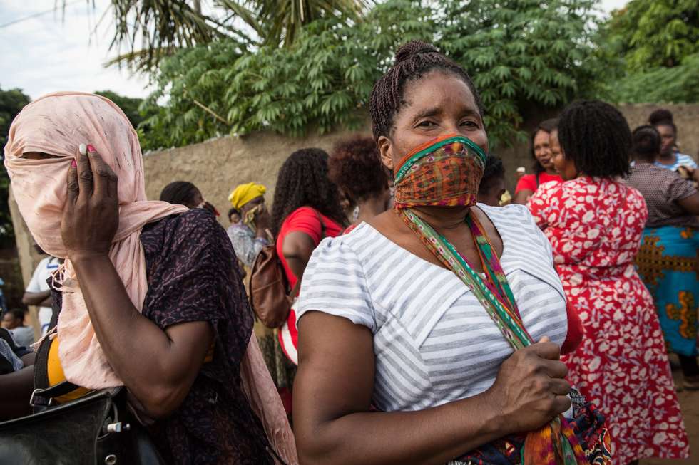 epa08337230 Women cover their faces as they wait for their bus at the Zimpeto Bus terminal in Maputo, Mozambique, 01 April 2020. Mozambique's parliament has approved the declaration of a state of emergency that was announced on Monday by the African country's president, Filipe Nyusi, and is set to remain in force throughout the month of April, in a bid to slow down the spread of the pandemic COVID-19 disease caused by the SARS-CoV-2 coronavirus.  EPA/RICARDO FRANCO