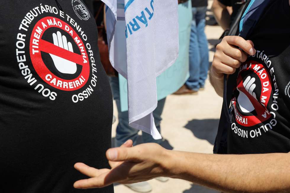 Trabalhadores dos impostos e alfândegas vestem t-shirts onde se lê "Sou Inspetor Tributário e Tenho Ougulho Nisso - Tirem a Mão da Minha Carreira!", em protesto pela revisão das carreiras especiais da Autoridade Tributária e Aduaneira, esta manhã junto ao Ministério das Finanças, em Lisboa, 27 de junho de 2019. MIGUEL A. LOPES/LUSA