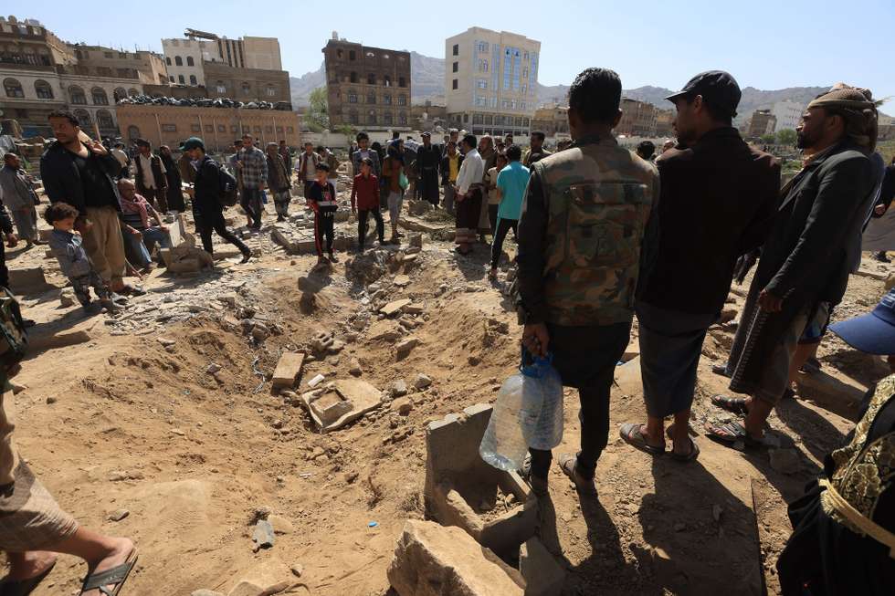 epa12042812 People inspect the scene of US airstrikes at a cemetery in Sana'a, Yemen, 20 April 2025. The United States has launched a wave of airstrikes since mid-March on at least four Houthis-controlled provinces of Yemen, including Sana'a, amid heightened tensions between the Houthis and the US over Houthi attacks on Israel and shipping in waters around Yemen, according to Houthis-run Al-Masirah TV.  EPA/YAHYA ARHAB