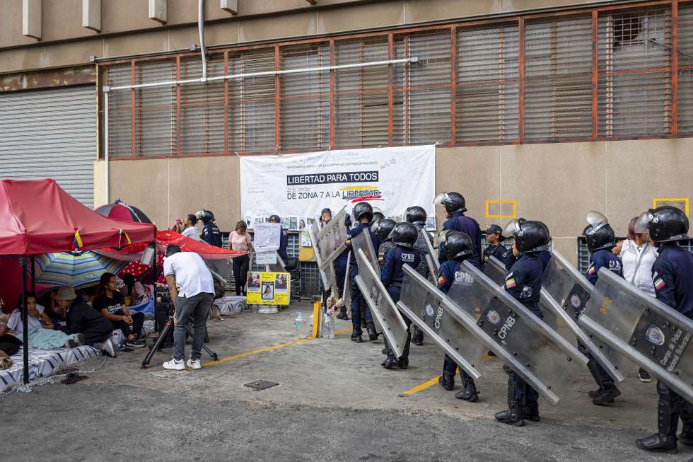 epa12747495 Members of the Bolivarian National Police (PNB) stand guard in front of the command center known as Zone 7 during a hunger strike carried out by relatives of political prisoners in Caracas, Venezuela, 16 February 2026. Ten women who are relatives of political prisoners in Venezuela have been on hunger strike for more than 48 hours outside a police headquarters, some of whom have already suffered health problems related to their hunger strike.  EPA/MIGUEL GUTIERREZ