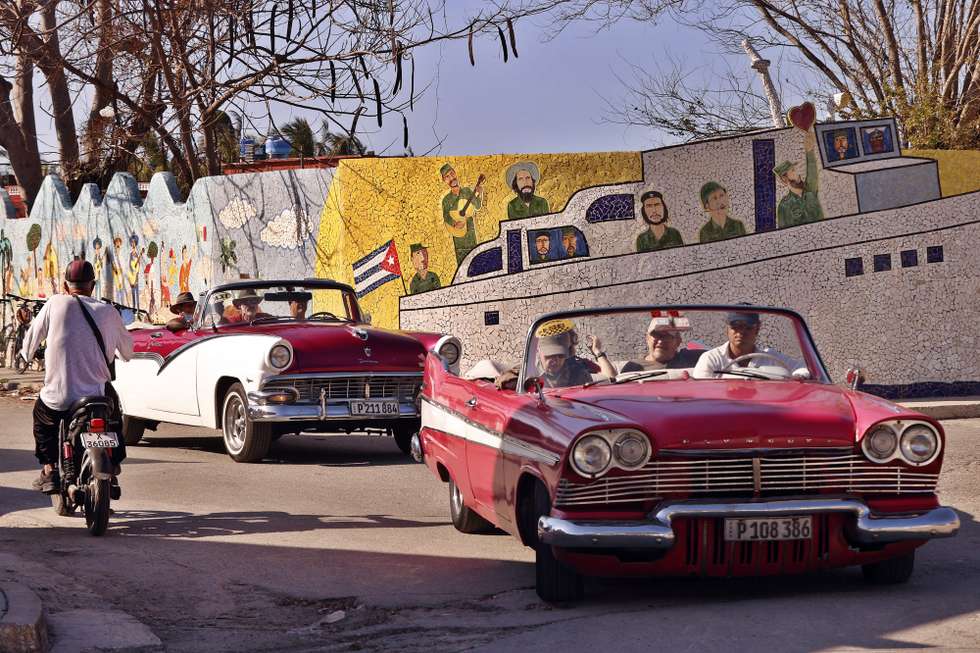epaselect epa12725508 Tourists ride classic cars in front of a mural by artist Fuster in Jaimanitas in Havana, Cuba, 10 February 2026. The temporary suspension of all flights to Cuba from Canada is affecting the island's tourism industry, as Canadians account for 40 percent of its visitors.  EPA/ERNESTO MASTRASCUSA
